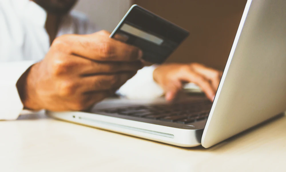 Woman managing e-commerce store on laptop with packages